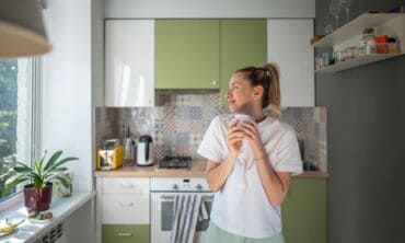 Moteris su kavos puodeliu